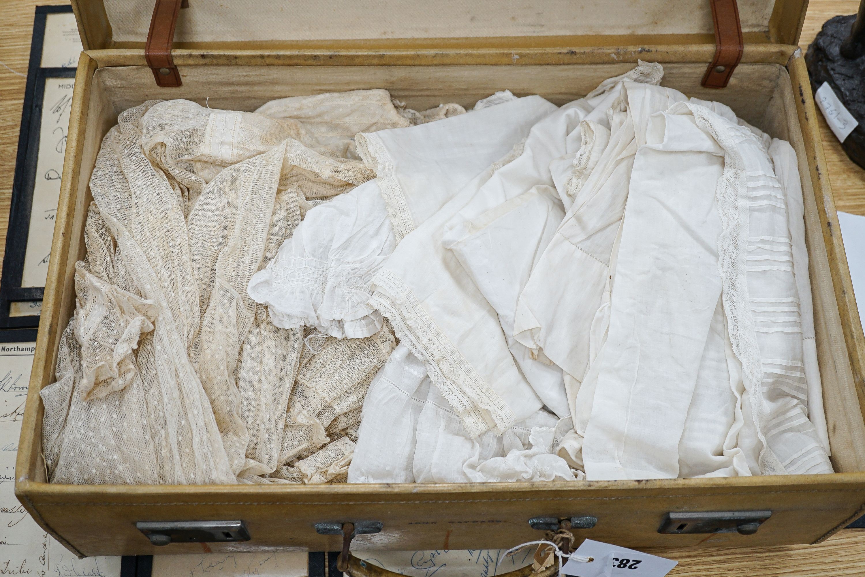 Various christening gowns, 2 dresses in a suitcase